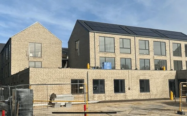 Nybygget ejendom med skalmuring og solceller